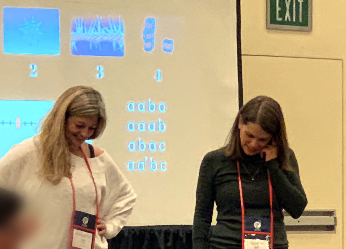 Diana Hawley and Beth Brown side by side in front of a projected slide of rhythm patterns